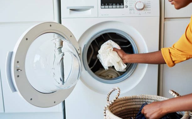 Cropped shot of an unrecognizable woman doing her laundry at home
